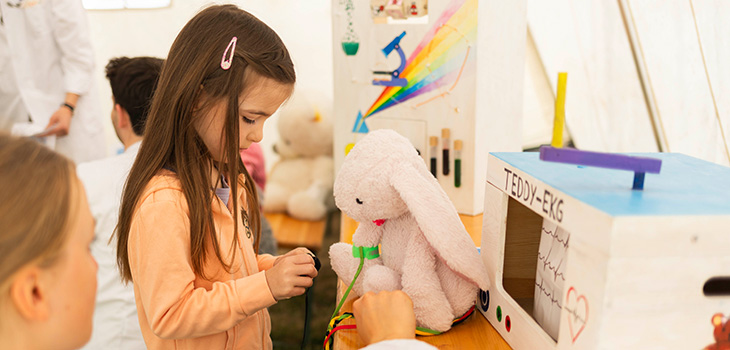 Mit viel Einfühlungsvermögen erklärt eine Medizinstudierende einer kleinen Besucherin den „Bluttest“ für das Kuscheltier – in der Teddyklinik wird Medizin spielerisch und kindgerecht erlebbar gemacht. Foto: Sarah Kossmann/UMMD